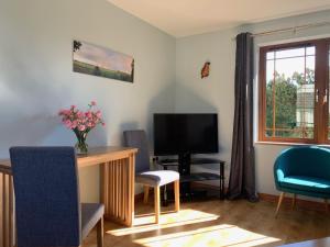 un soggiorno con tavolo, sedie e televisione di Relaxing Retreat on the Stunning Ards Peninsular a Millisle