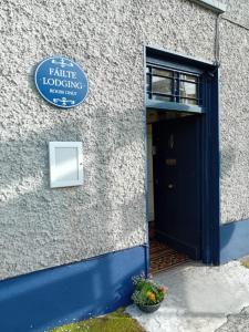 Una puerta a un edificio con un cartel. en Fáilte Lodging Kenmare Town Centre, en Kenmare
