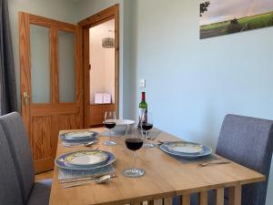 un tavolo in legno con bicchieri di vino sopra di Relaxing Retreat on the Stunning Ards Peninsular a Millisle