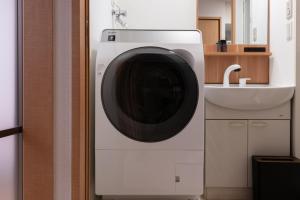 - un lave-linge dans une salle de bains à côté d'un lavabo dans l'établissement Belvoir Island Town - Vacation STAY 16352, à Osaka