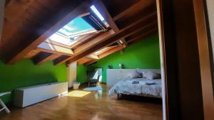 een slaapkamer met een bed en een groene muur bij ALLOGGIO IL TRULLO in Borso del Grappa
