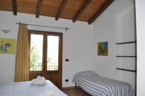 een slaapkamer met 2 bedden en een raam bij Borgo San Francesco in Gioiosa Marea