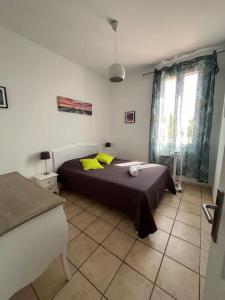 ル・サムビュクにある"Le Miradou" gite rural Camargueのベッドルーム1室(黄色い枕のベッド1台付)