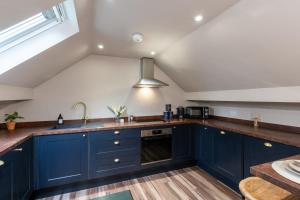 a kitchen with blue cabinets and a sink at Lud's Snug in Buxton
