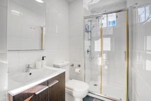 a white bathroom with a toilet and a shower at Central Apartment 2 bedrooms Netflix WIFI in Gandía +31 photos