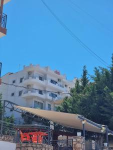 a building with red chairs in front of it at Bill's Apartments in Sarandë