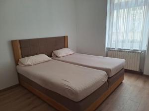 2 Betten in einem kleinen Zimmer mit 2 Fenstern in der Unterkunft Hotel zur Post in Bacharach