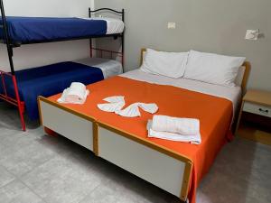 HOTEL PICCARI Nuova gestione في ريميني: غرفة نوم بسريرين بطابقين مع مناشف على السرير