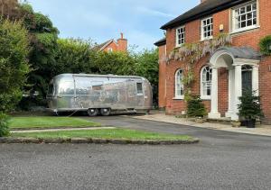 a silver trailer parked in front of a house at Airstream Experience in Knutsford