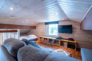 ein Wohnzimmer mit einem Sofa und einem Flachbild-TV in der Unterkunft Villa Peso2 - 8 henkilölle, HimosYkkösen alue, 70m²+40m² in Jämsä