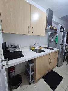 a small kitchen with a sink and a refrigerator at JKrib Studio at The Residences Commonwealth in Manila