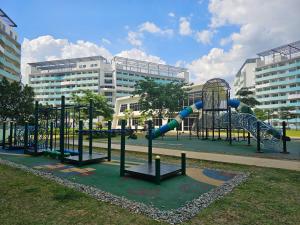 a playground with a slide in a park with buildings at JKrib Studio at The Residences Commonwealth in Manila