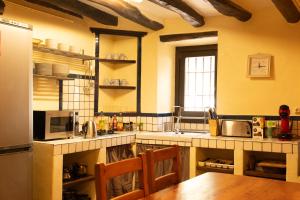 cocina con mesa y nevera en Masia en plena naturaleza y tranquilidad en San Quintín de Mediona