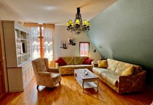 uma sala de estar com um sofá e cadeiras e um lustre em Apartmenthaus im holländischen Viertel em Potsdam