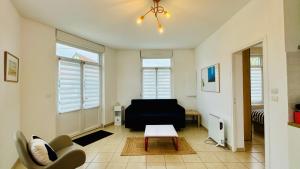 a living room with a couch and a table at La scintillante au coeur de Merlimont Plage in Merlimont