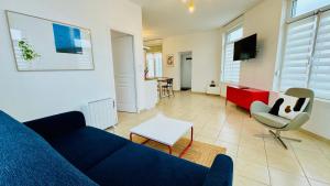 a living room with a blue couch and a table at La scintillante au coeur de Merlimont Plage in Merlimont