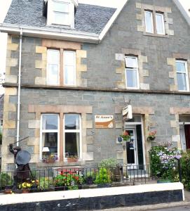 a large brick building with a clock on the front of it at St Annes Guest House in Oban