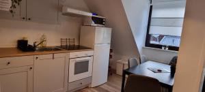 a small kitchen with a white refrigerator and a table at TAKAppartement Dormagen in Dormagen