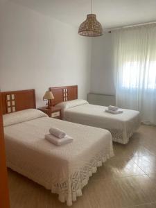 1 dormitorio con 2 camas y toallas. en Alojamiento turístico Noalejo ( Granada/ Jaén ) en Noalejo