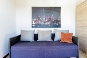 Sofá púrpura con almohadas coloridas en una habitación en Willa Alexandria - Domki, Apartamenty, Pokoje z Basenem, en Karwia