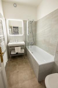 uma casa de banho com uma banheira, um lavatório e um WC. em Hôtel de la Poste em Avallon