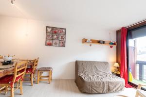 a living room with a table and a chair at Le Corbier - studio avec belle vue montagne in Villarembert
