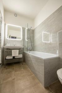 łazienka z wanną i umywalką w obiekcie Hôtel de la Poste w mieście Avallon