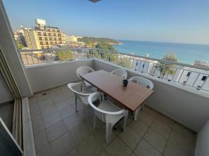 een balkon met een tafel en stoelen en de oceaan bij HOLIDAY APART 50 meters to BEACH, Sea view apartments in Didim