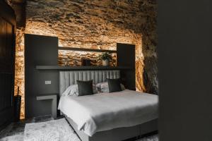 1 dormitorio con cama y pared de ladrillo en Villa Antica Colonia - Lake Orta - Suite Apartments Adults Only - SPA & Wellness en Pettenasco