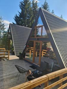 a woman laying on the deck of a tiny house at Cabane A-frame CeziAde Tihuta in Piatra Fantanele