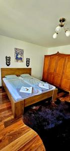 uma cama grande num quarto com mobiliário em madeira em Forest Luxury Apartman em Dorogháza