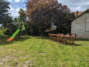 um parque infantil com uma mesa e um baloiço verde em Le Gîte des Roses em Essey