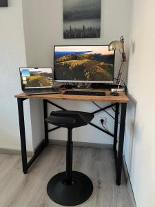 a desk with a computer and a laptop on it at Ferienwohnung Voerde-Götterswickerhamm-"die Perle am Niederrhein" in Götterswickerhamm