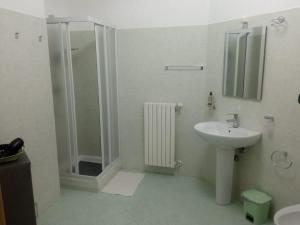 La salle de bains blanche est pourvue d'un lavabo et d'une douche. dans l'établissement 4 Seasons b&b, à Potenza