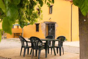 a table and chairs in front of a yellow building at Masia en plena naturaleza y tranquilidad in San Quintín de Mediona