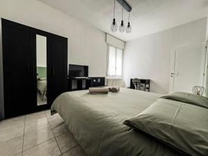 1 dormitorio con 1 cama grande y TV en CasaVivi Fiera, en Bolonia