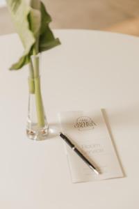 a note and a vase with a flower and a pen at Villa Antica Colonia - Lake Orta - Suite Apartments Adults Only - SPA & Wellness in Pettenasco