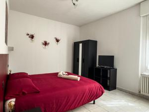 1 dormitorio con cama roja y TV en CasaVivi Fiera, en Bolonia