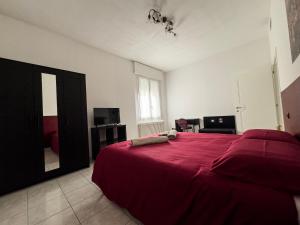 1 dormitorio con cama roja y espejo en CasaVivi Fiera, en Bolonia