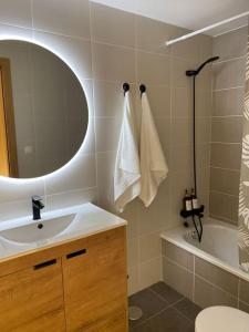 a bathroom with a sink and a mirror and a tub at Apartamento a pie de playa La Pepa in Burela de Cabo +19 photos