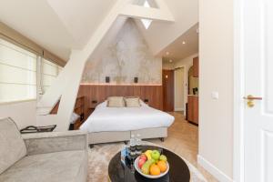 um quarto com uma cama e uma mesa com uma tigela de fruta em Novallure Villa Margaretha - Short Stay Apartments em Rijswijk