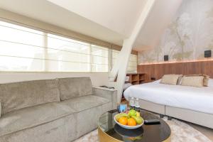een woonkamer met een bank en een bed bij Novallure Villa Margaretha - Short Stay Apartments in Rijswijk