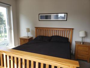 a bedroom with a bed with a wooden frame and a window at Indomitable in Colindale