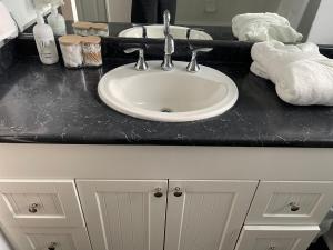 a bathroom counter with a sink and a black counter top at 43 Ave Farm House Langley in Aldergrove