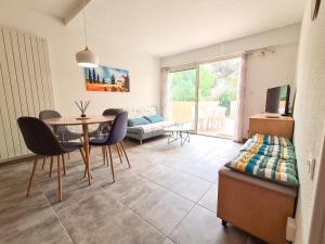 uma sala de estar com uma mesa e cadeiras e um sofá em La perle du Roussillon em Fitou