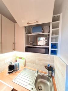 uma cozinha com um lavatório e um micro-ondas em La perle du Roussillon em Fitou