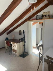 an attic room with a desk and a table at La Mansarda di Jt in Varazze +2 photos