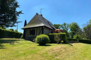 een klein huis met een dak op een grasveld bij Charming Normandy House in Fort-Moville