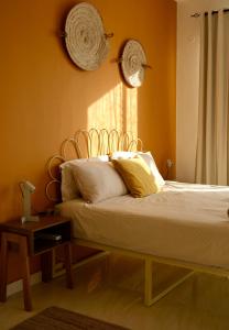a bedroom with a bed with yellow walls and a table at Al Rawnaq Studio in Al Ḩamrāʼ
