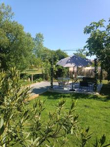 a table and an umbrella in a yard at Chambre d'Hôtes Les Macarons de Tata in Sainte-Eulalie